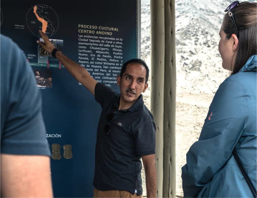 Tour group walking through ancient Caral city structures